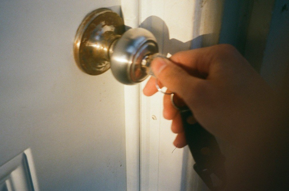 Main tournant une clé dans la poignée d'une porte lors d'un dépannage